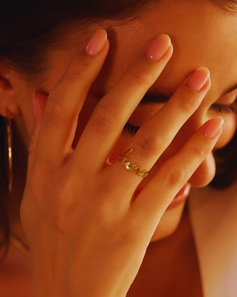 Woman wearing Whispering Wush custom name ring.